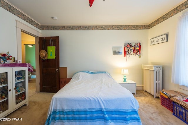 bedroom with radiator and light carpet