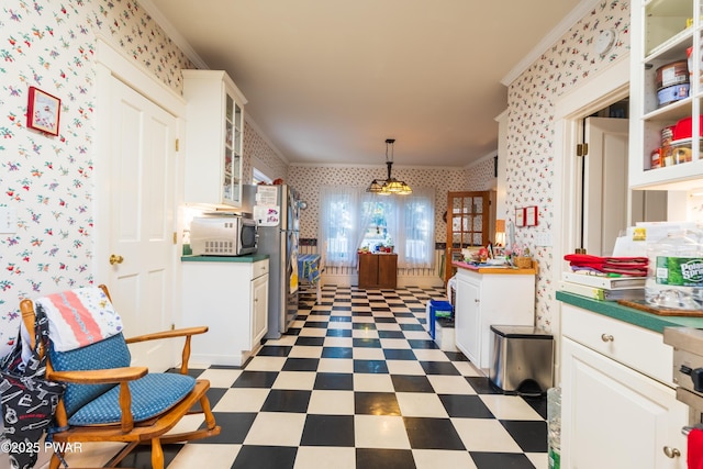 kitchen featuring stainless steel fridge, white cabinetry, pendant lighting, and crown molding