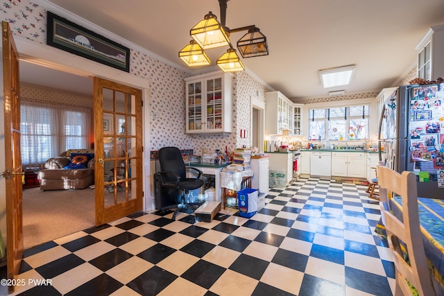 kitchen with white cabinets, white dishwasher, sink, crown molding, and decorative light fixtures