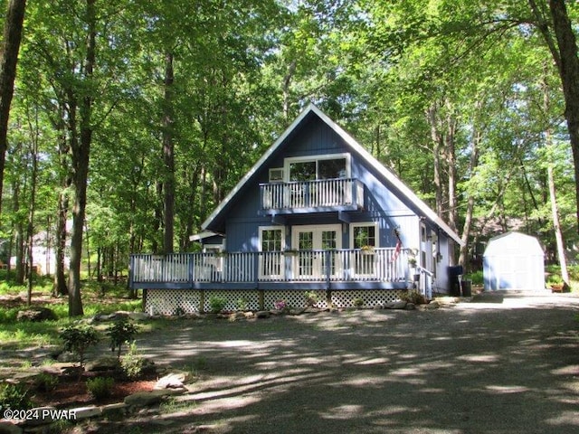 view of front of home with a storage unit and a wooden deck