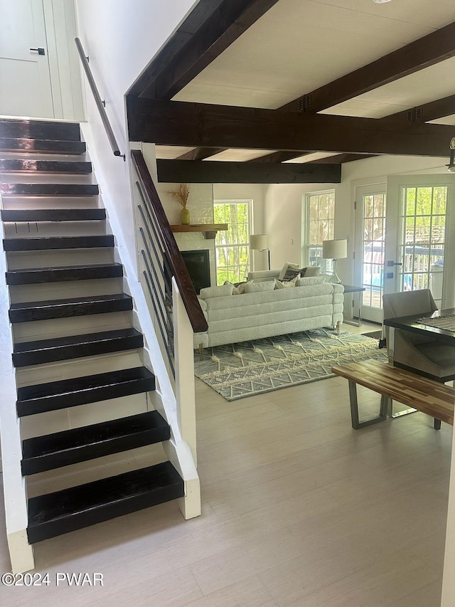 stairs with beamed ceiling and a healthy amount of sunlight