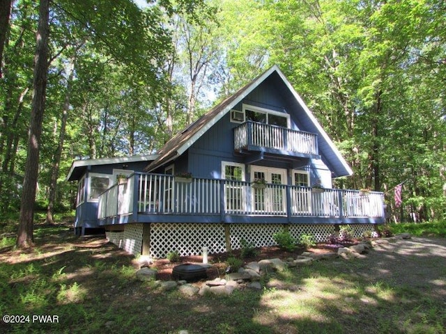 rear view of property with a balcony and a deck