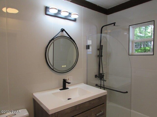 bathroom with vanity, tasteful backsplash, toilet, and tile walls