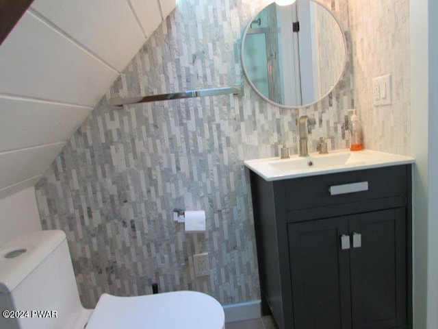 bathroom with vanity, toilet, and vaulted ceiling