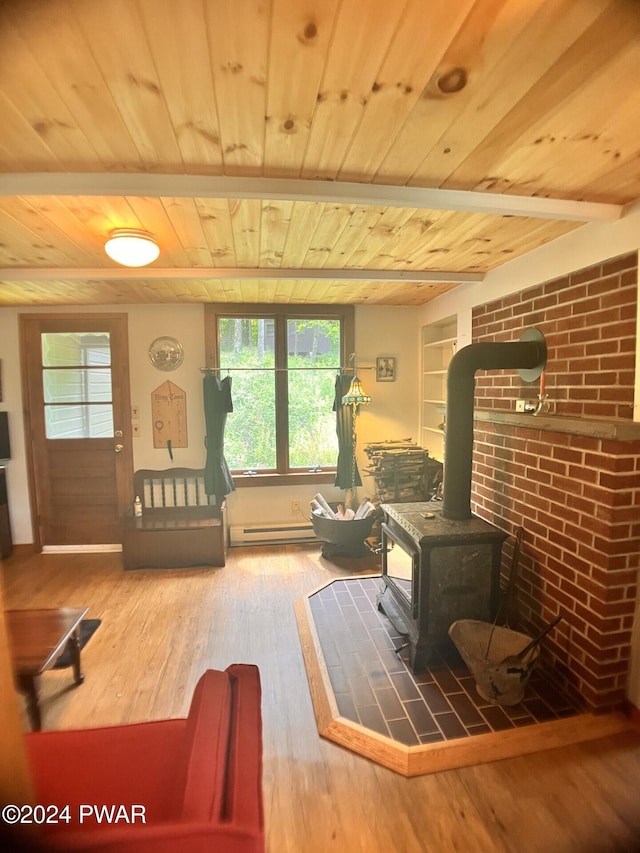 living area featuring hardwood / wood-style flooring, wooden ceiling, a wood stove, and a baseboard heating unit