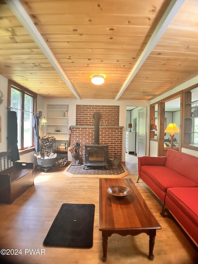 living room with beamed ceiling, a wood stove, hardwood / wood-style flooring, and wooden ceiling