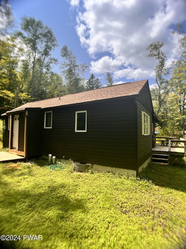 view of side of home with a yard and a deck