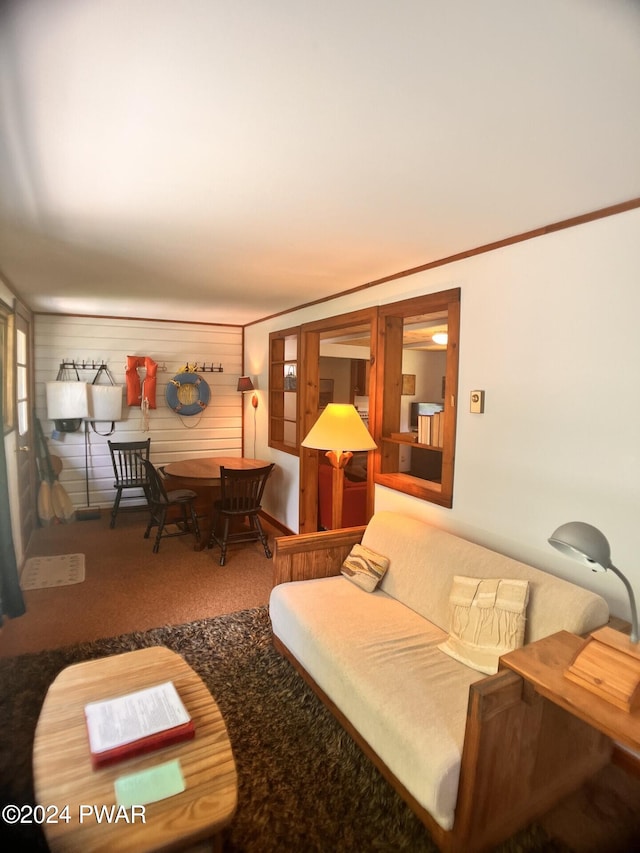 carpeted living room featuring wood walls and crown molding