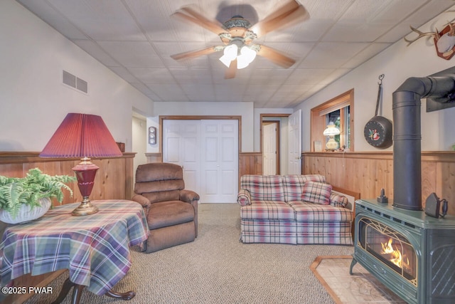 37 Rockpoint Ct, Lake Ariel, PA 18436 - carpeted living area with a wood stove, ceiling fan, wainscoting, and wooden walls