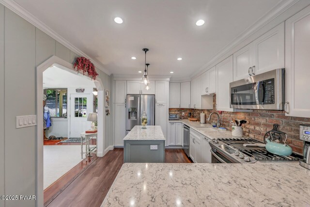 37 Rockpoint Ct, Lake Ariel, PA 18436 - kitchen with stainless steel appliances, dark wood finished floors, light stone counters, crown molding, and backsplash