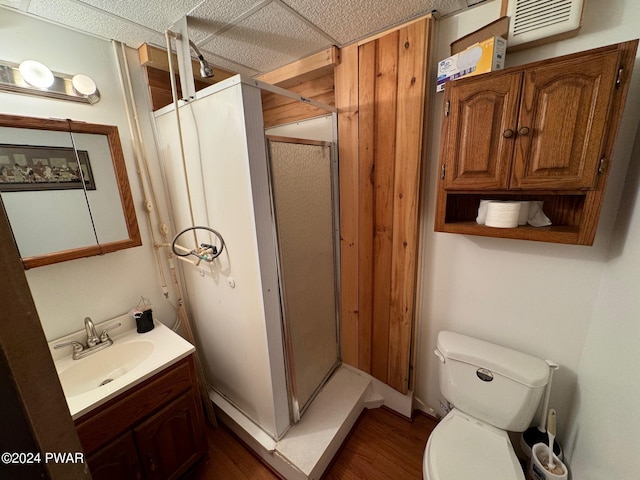 bathroom featuring toilet, a drop ceiling, vanity, and hardwood / wood-style flooring