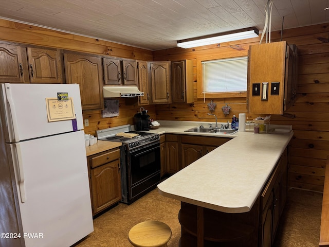 kitchen featuring wood ceiling, black range with gas stovetop, sink, white refrigerator, and wood walls