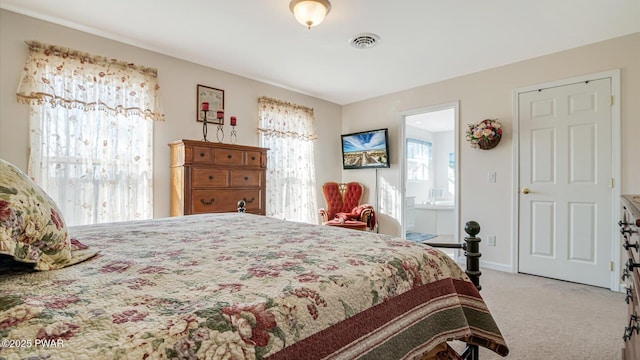carpeted bedroom with connected bathroom, baseboards, and visible vents