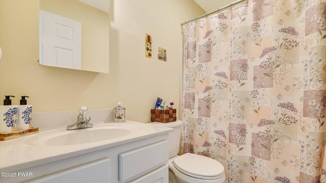 bathroom featuring a shower with shower curtain, toilet, and vanity