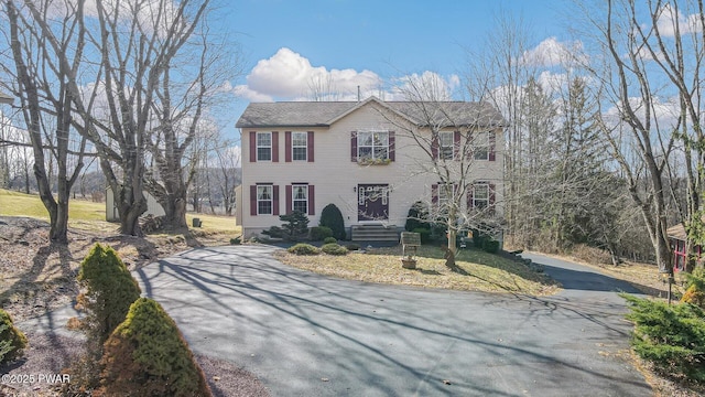 colonial home featuring aphalt driveway