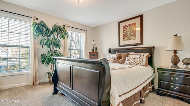 bedroom with light colored carpet and baseboards