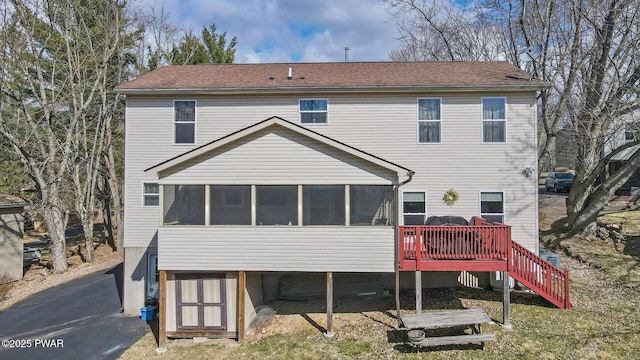 rear view of house featuring cooling unit, a sunroom, and stairs