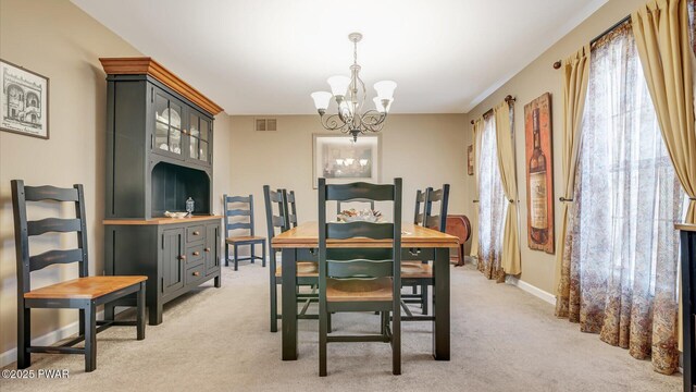 dining space with baseboards, visible vents, a notable chandelier, and light colored carpet