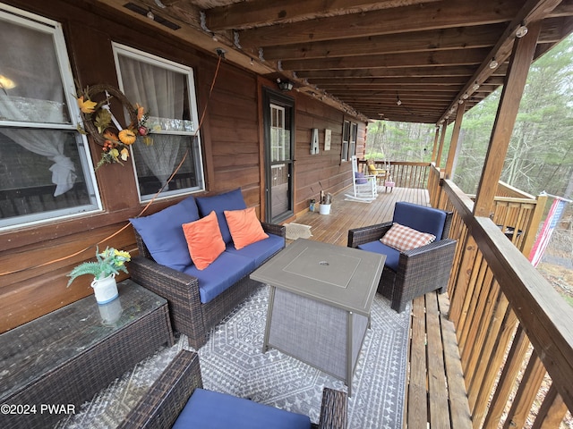 wooden terrace with an outdoor living space