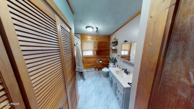 bathroom featuring ornamental molding, vanity, a baseboard radiator, toilet, and wood walls