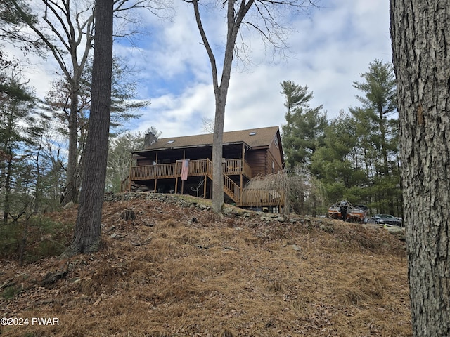 rear view of property featuring a wooden deck