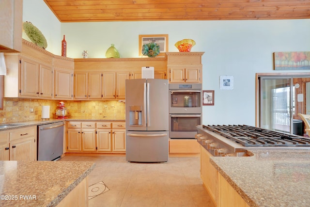 kitchen featuring light tile patterned floors, appliances with stainless steel finishes, light stone countertops, light brown cabinetry, and tasteful backsplash