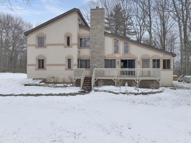 view of front of home with a chimney and stucco siding