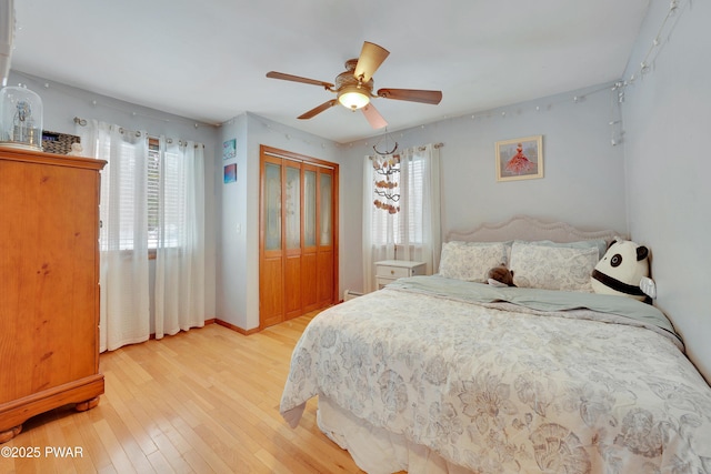 bedroom with light wood-style floors, a closet, multiple windows, and baseboards