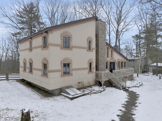 view of snowy exterior with stucco siding