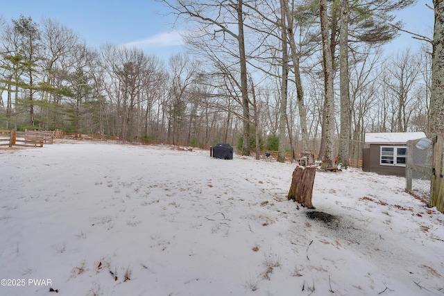 yard covered in snow with a garage and fence