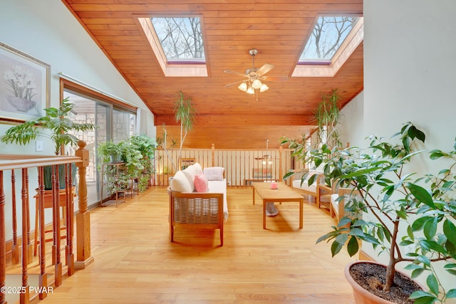 interior space with high vaulted ceiling, light wood-type flooring, and a skylight