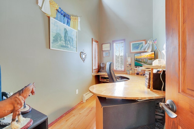 office space featuring a baseboard radiator and wood finished floors