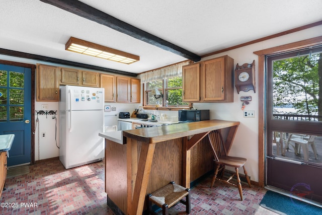 71 Boulder Point Rd, Lakeville, PA 18438 - kitchen featuring freestanding refrigerator, brick patterned flooring, black microwave, brown cabinetry, and beam ceiling