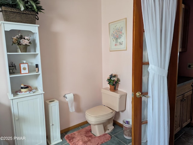 bathroom featuring baseboards, toilet, and tile patterned floors