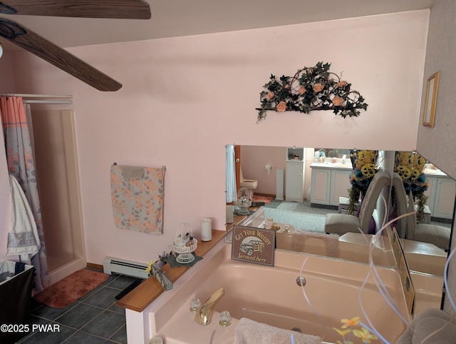 full bathroom featuring a baseboard radiator, tile patterned flooring, toilet, and a bath