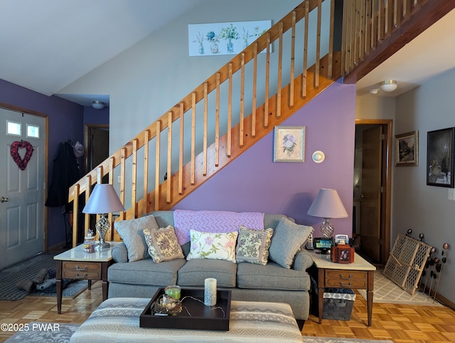 living room with vaulted ceiling, baseboards, and stairs