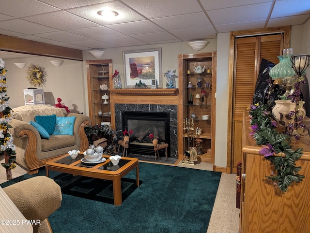 carpeted living area with a paneled ceiling and a premium fireplace