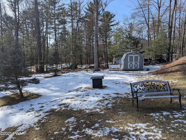 snowy yard featuring a storage shed