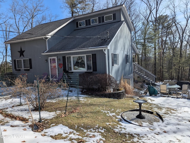 view of front of house with a shingled roof and stairs