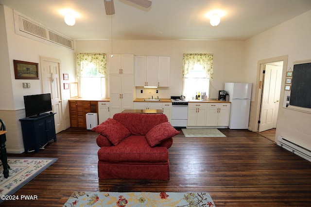 living room with plenty of natural light, ceiling fan, sink, and dark wood-type flooring