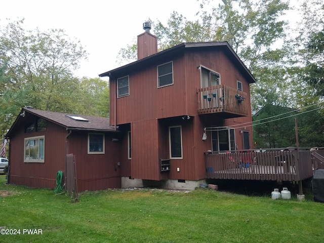 rear view of property featuring a wooden deck, a yard, and a balcony