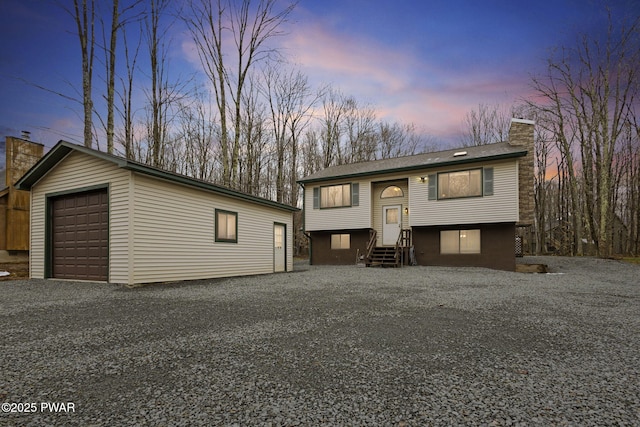 104 Rockway Rd, Lake Ariel, PA 18436 - bi-level home featuring an outdoor structure, a garage, gravel driveway, a chimney, and entry steps