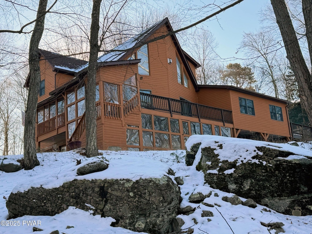 snow covered property with a deck