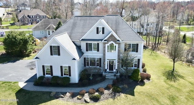 view of front of house featuring a front yard and roof with shingles