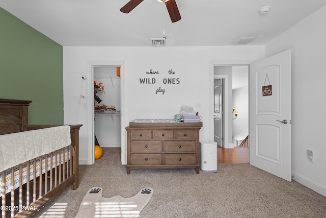 bedroom with carpet, a closet, visible vents, a spacious closet, and a ceiling fan