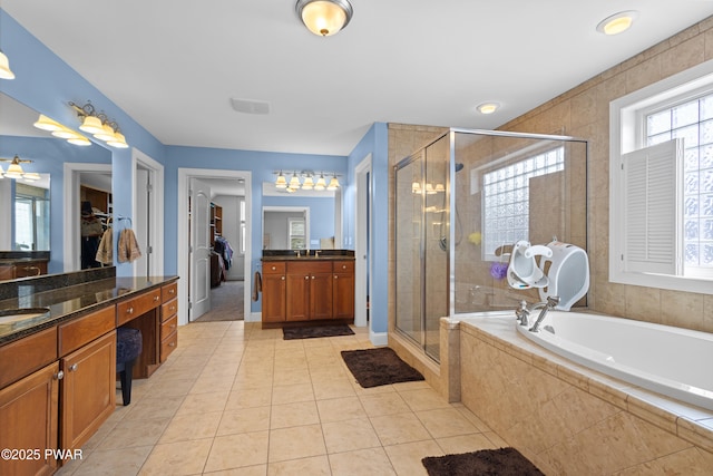 full bath featuring a stall shower, tile patterned flooring, a bath, and vanity