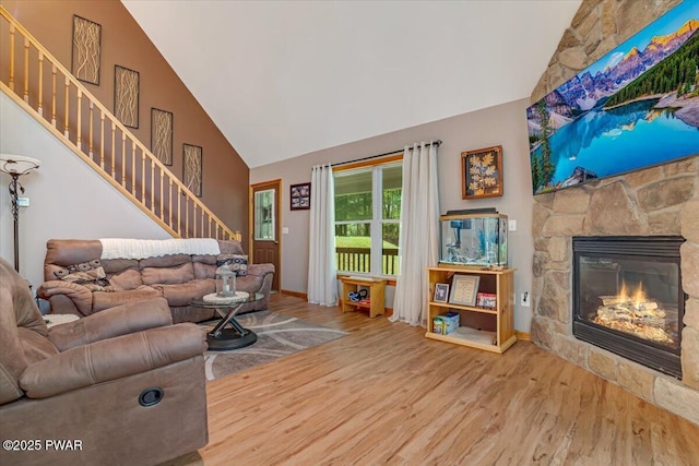 111 Sun Valley Dr, Tafton, PA 18464 - living room featuring high vaulted ceiling, wood finished floors, a stone fireplace, and stairway