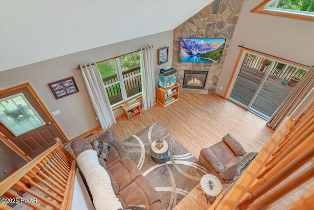 111 Sun Valley Dr, Tafton, PA 18464 - living area with healthy amount of natural light, a stone fireplace, wood finished floors, and high vaulted ceiling