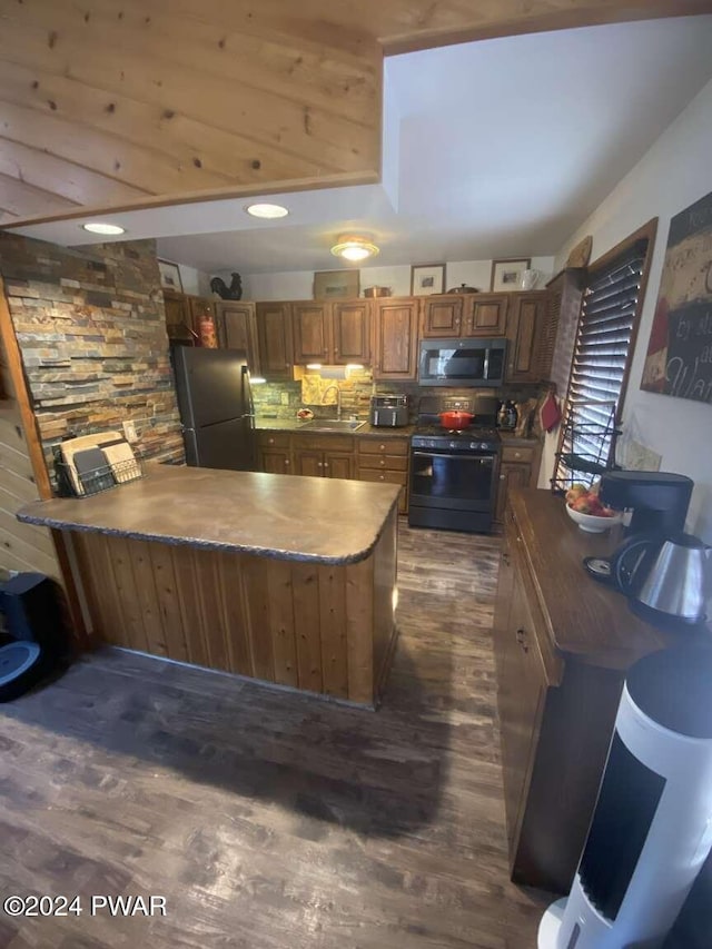 kitchen featuring sink, a center island, dark wood-type flooring, decorative backsplash, and appliances with stainless steel finishes