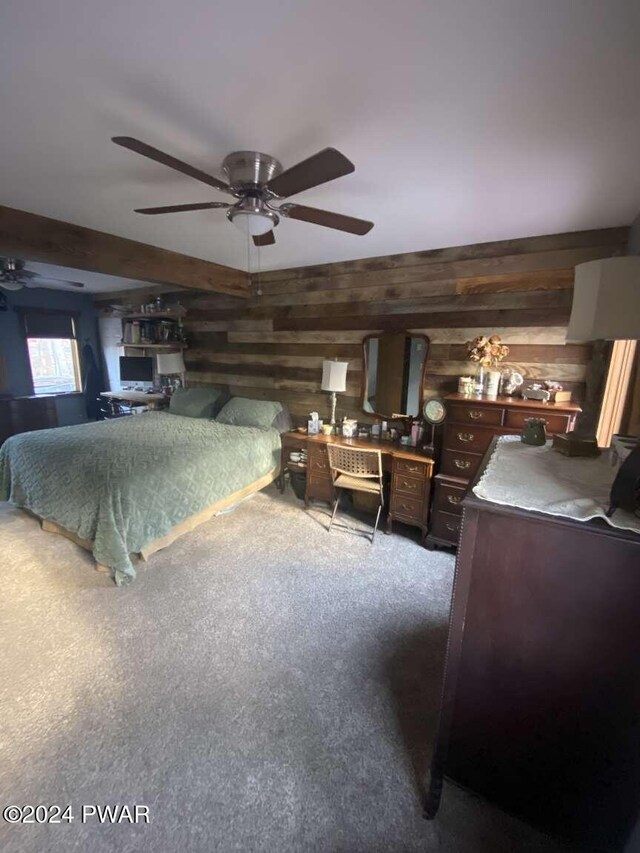 bedroom with carpet, ceiling fan, and wooden walls